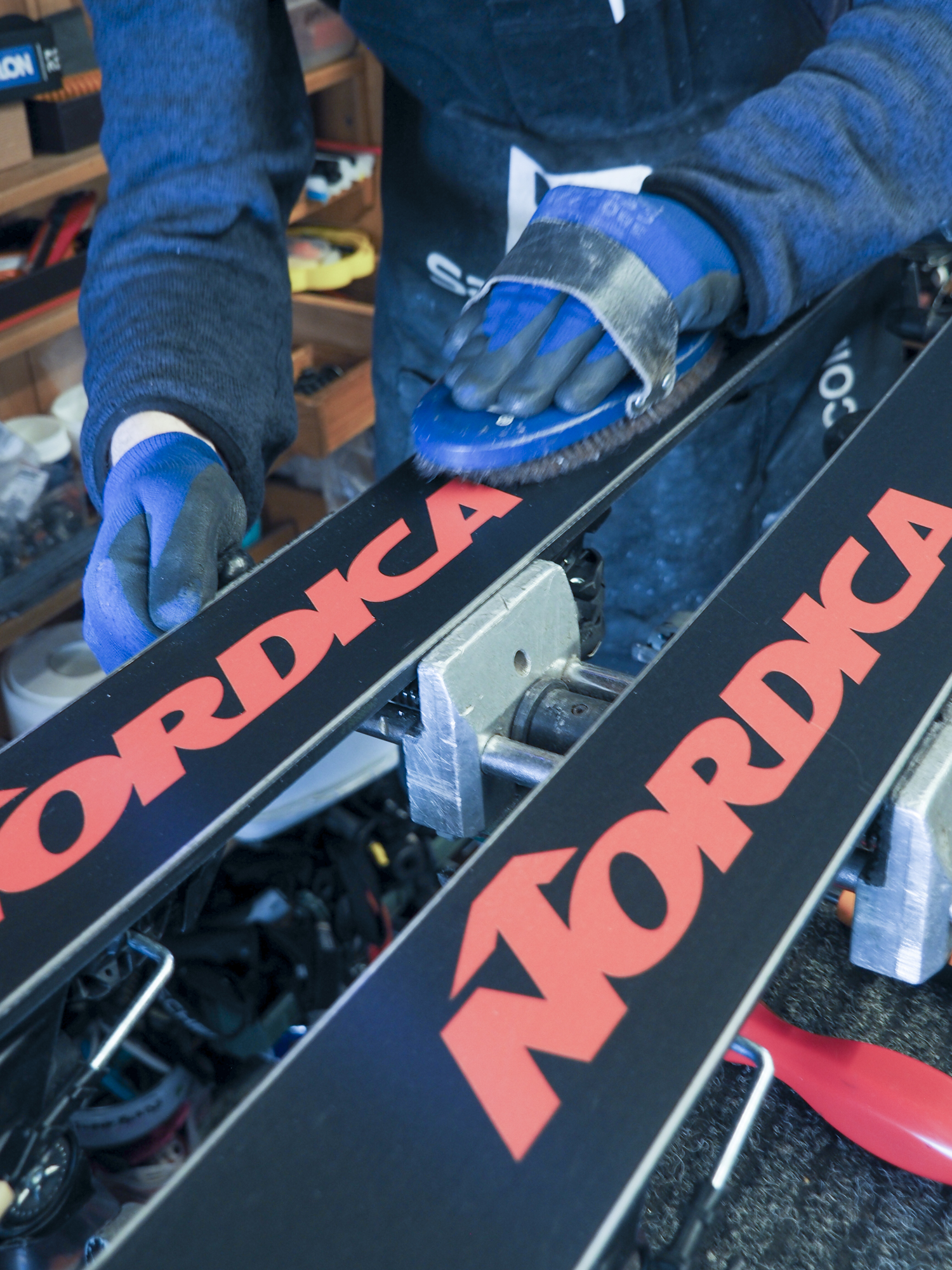 Tecnico che spazzola la soletta degli sci